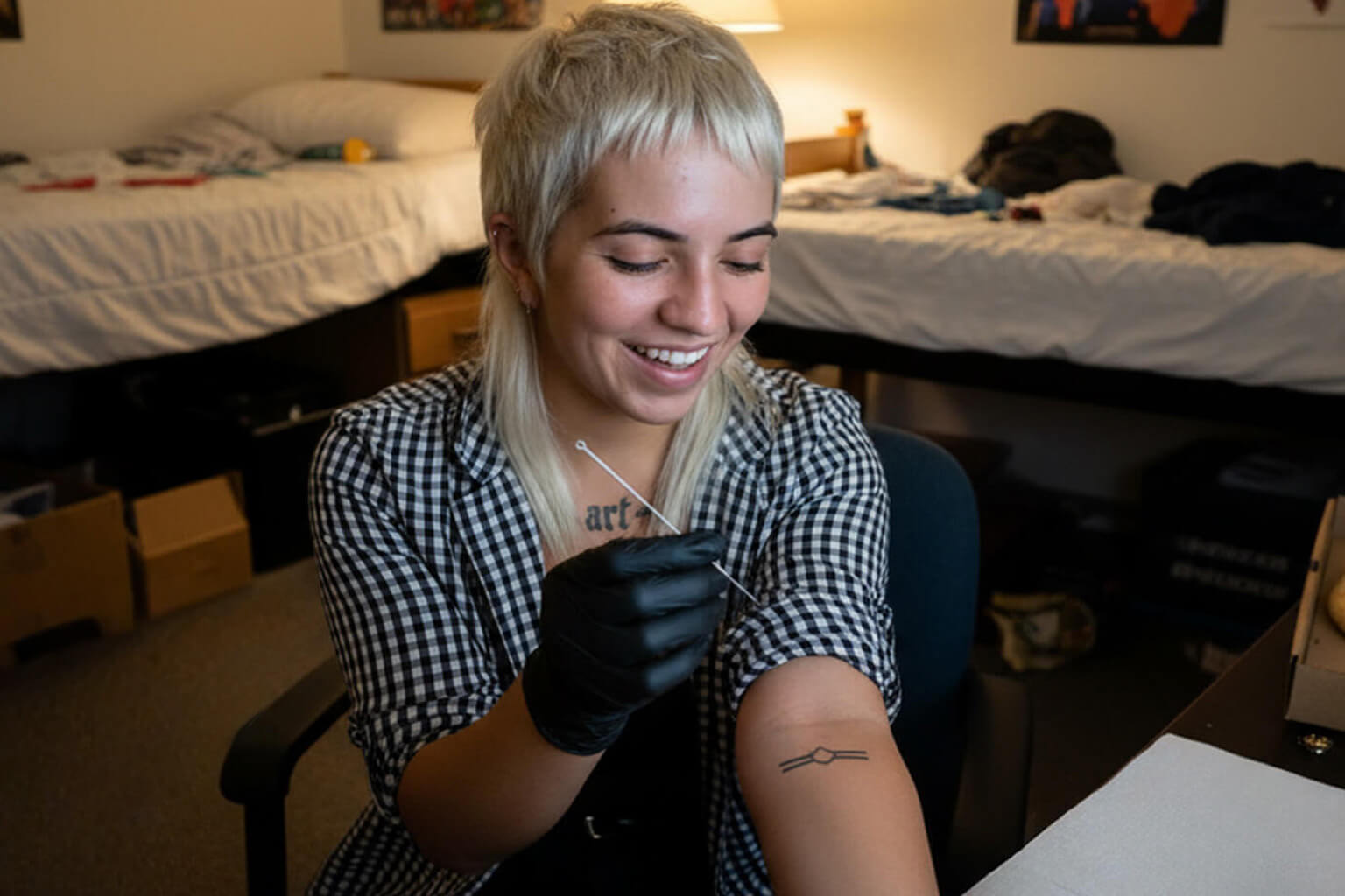 Brit doing a stick and poke tattoo