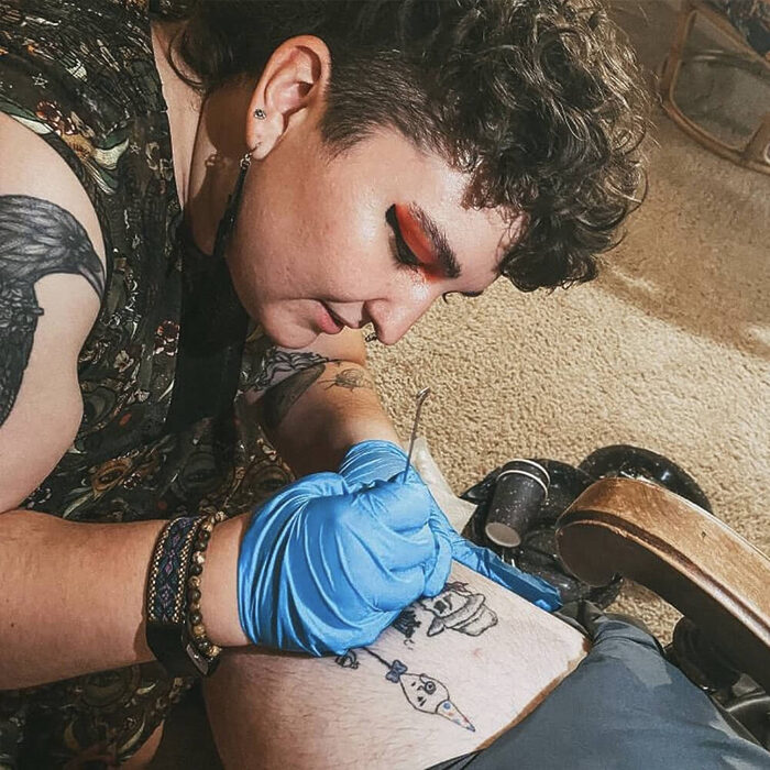 Friend tattooing a leg