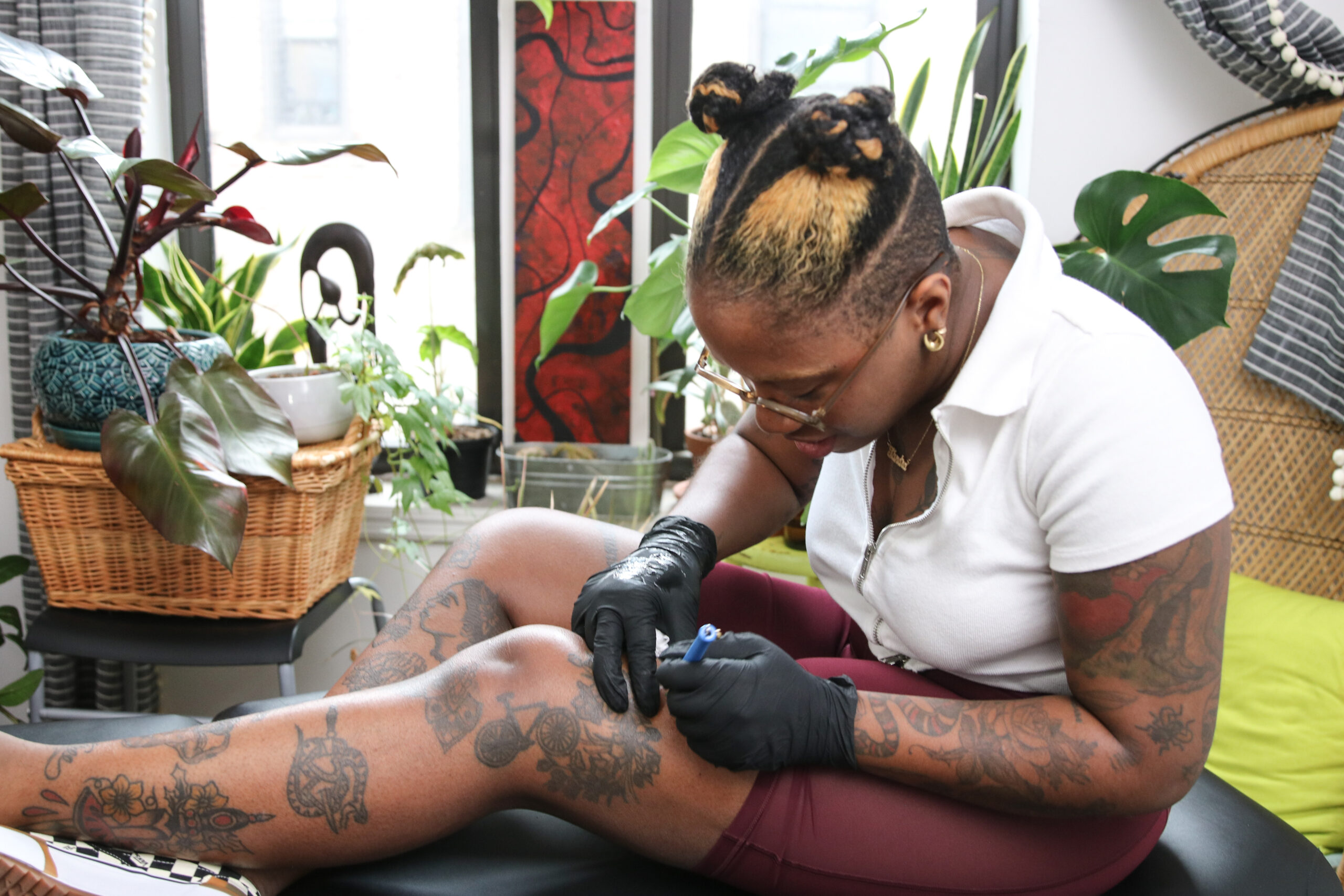 Person creating a DIY stick and poke tattoo at home using a hand poke tool and tattoo ink