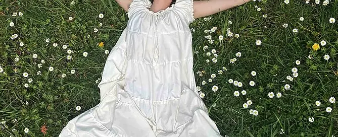 a person laying in flowers and grass from above